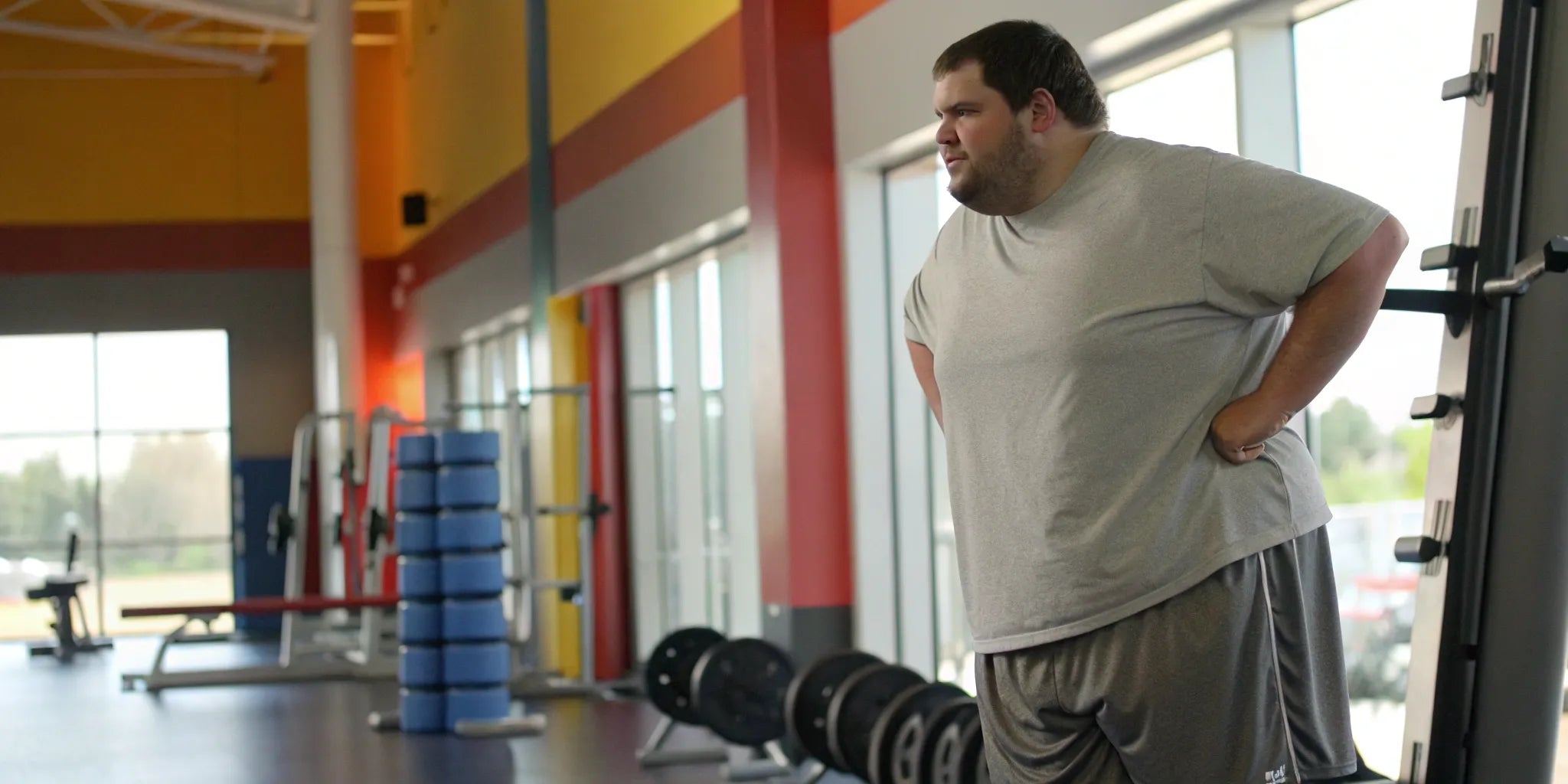 Man wearing big and tall gym shorts with a 10 inch inseam at a fitness center.