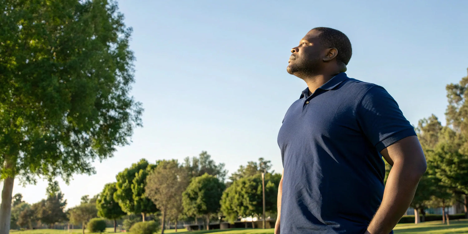 Man standing confidently in a well-fitting navy blue mens 5XL polo shirt.