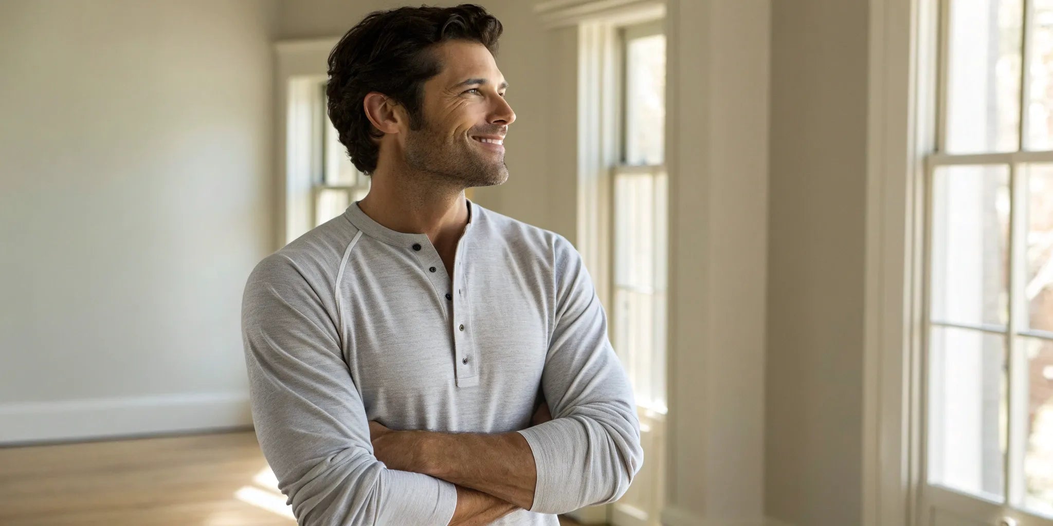 A man wearing one of the best big and tall henleys in a light gray style.