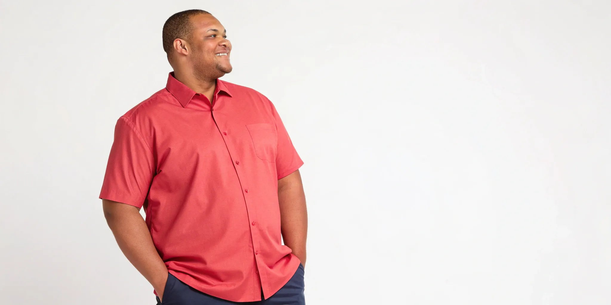 Smiling man in a well-fitting red short sleeve big and tall shirt.