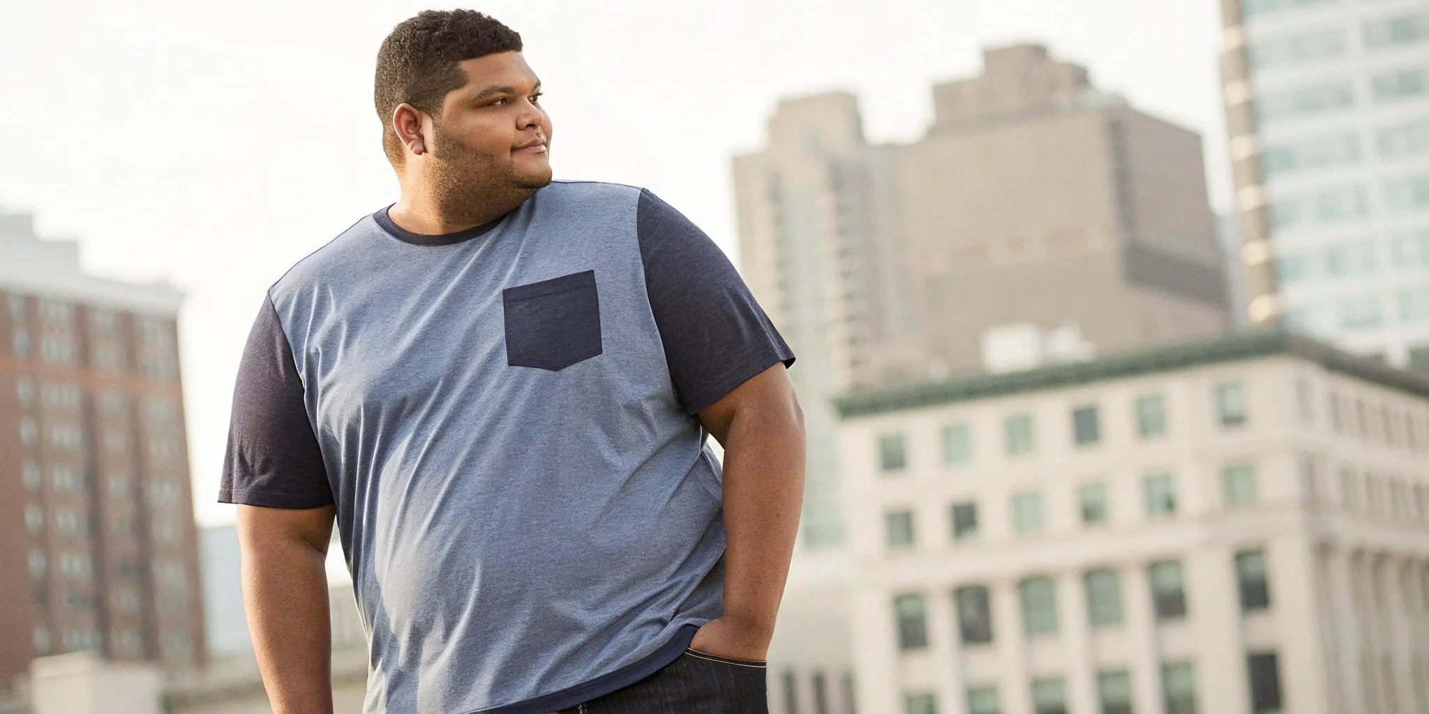 A man wearing a well-fitting big and tall t-shirt with a pocket.