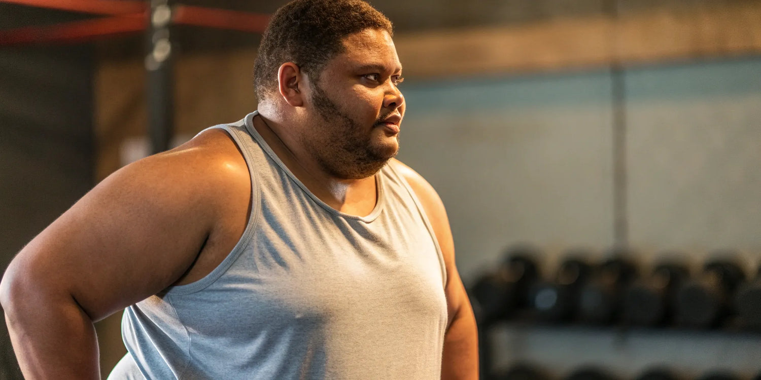 A big guy at the gym wearing one of the best light gray gym tanks.