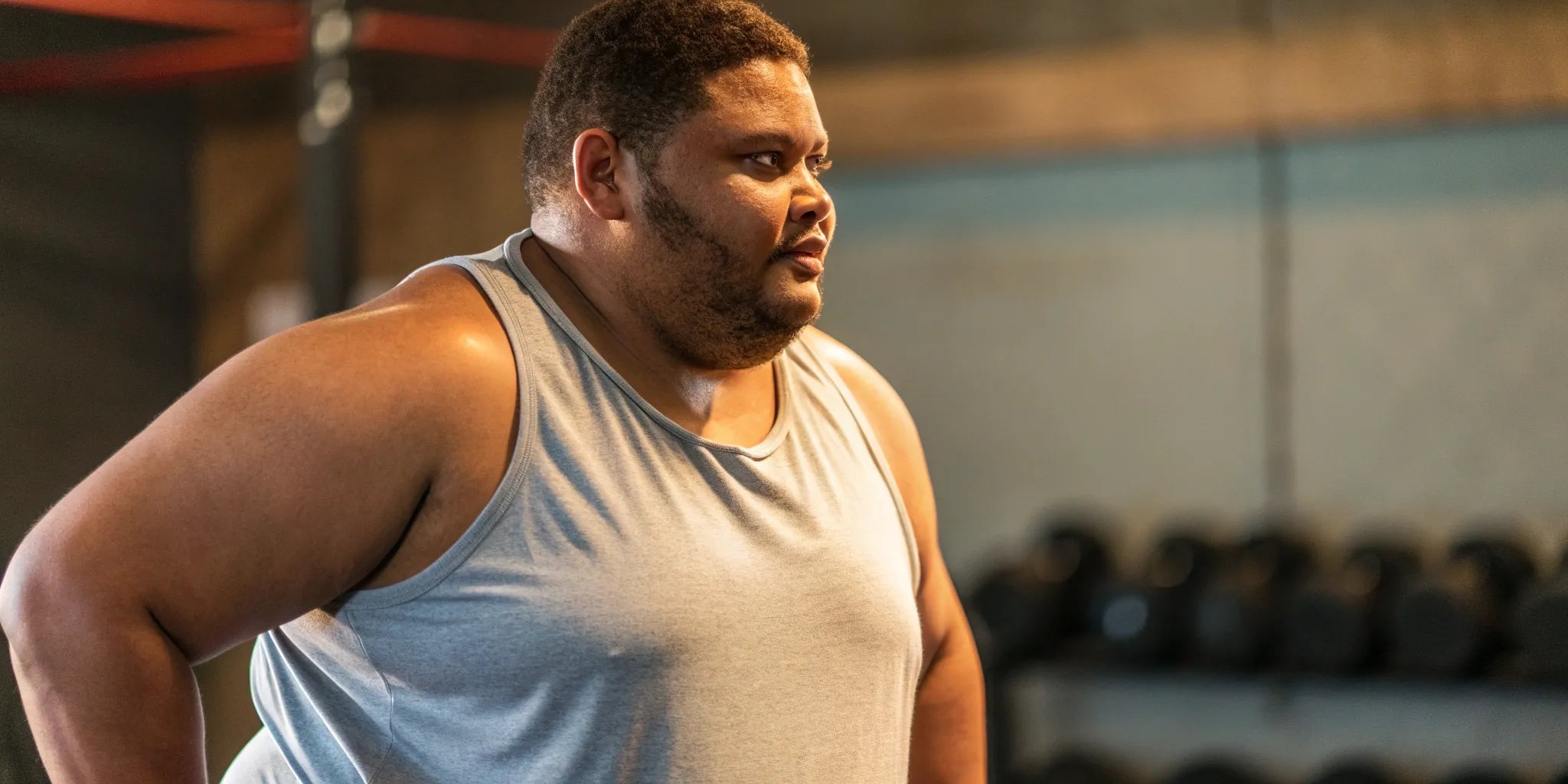 A big guy at the gym wearing one of the best light gray gym tanks.