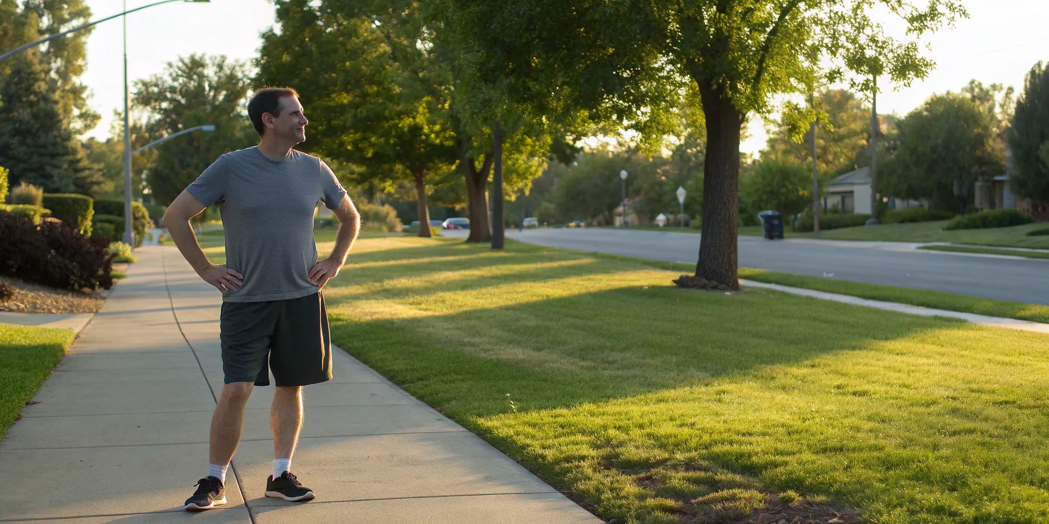Man standing on a sidewalk wearing plus size athletic shorts.